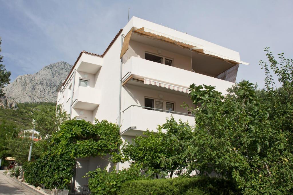 a white building with trees in front of it at Apartmani Arija in Promajna