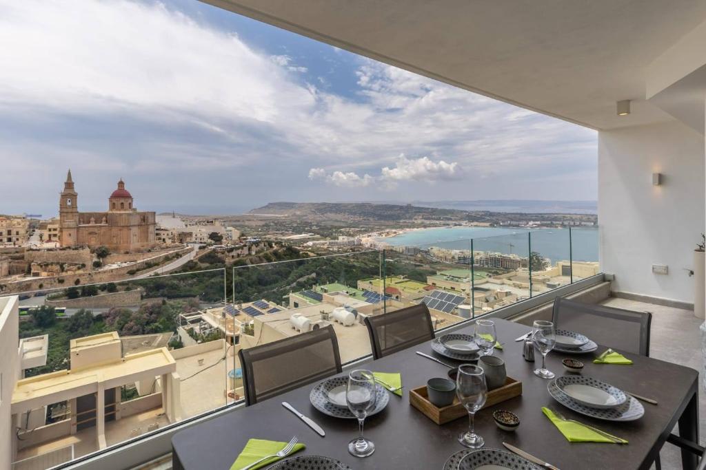 a dining room with a view of the city at Dome Sunset Views Apartment in Mellieħa