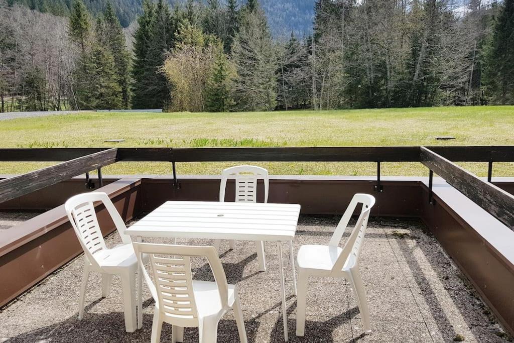 a white table and four chairs on a patio at SKI AUX PIEDS et PIEDS DANS L'EAU in Les Contamines-Montjoie