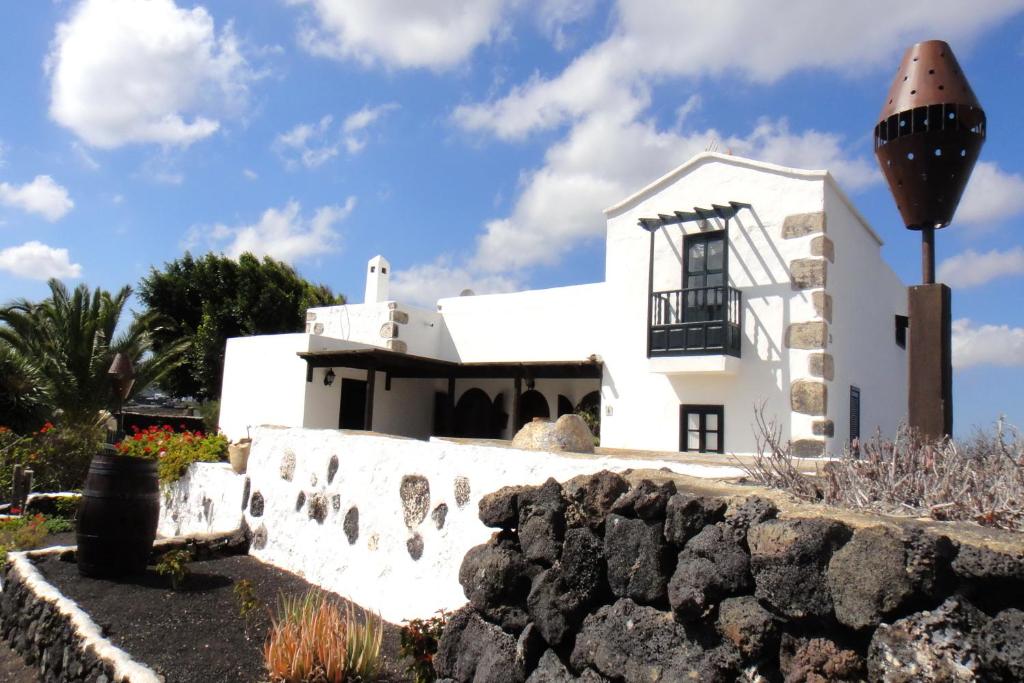 a white house with a stone wall at Finca El Oratorio in Masdache