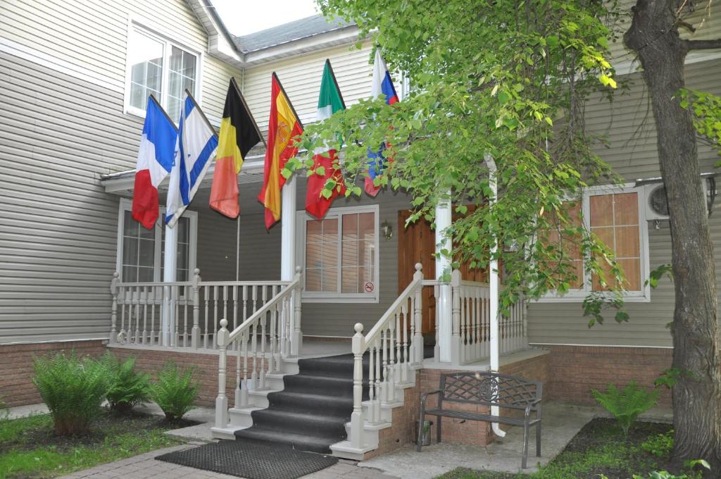 uma casa com bandeiras na frente em West Hotel em Pereslavl-Zalessky