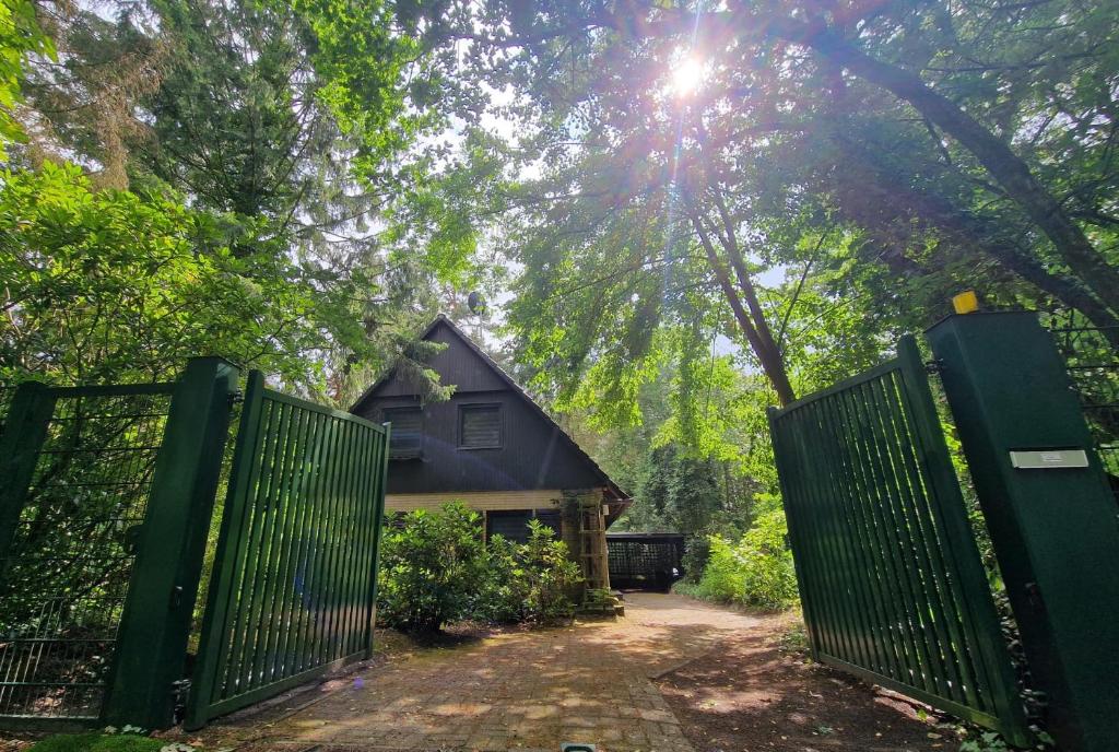 a gate to a house in the woods at Ferienhaus Thymian in Hatten bei Oldenburg - Idyllische Waldlage in Hatten