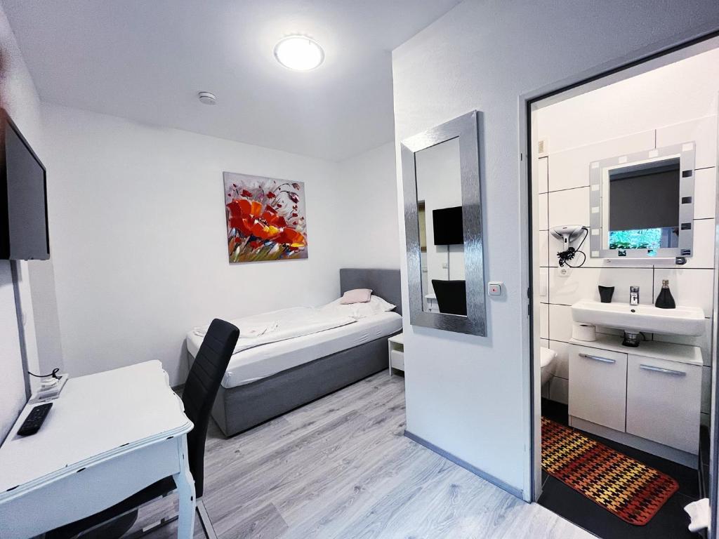 Kleines Zimmer mit einem Bett und einem Waschbecken in der Unterkunft Restaurant Donau in Hannover