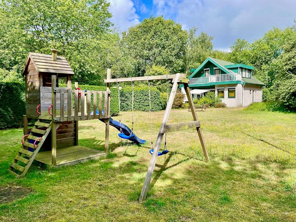 een houten speeltuin met een glijbaan en een schommel bij Vakantiehuis Jacobo in Burgh Haamstede