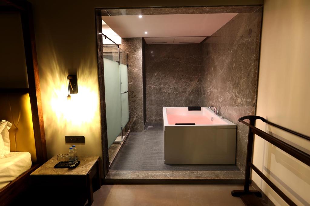 a bathroom with a bath tub and a sink at Golden Fields Resort in Mulshi
