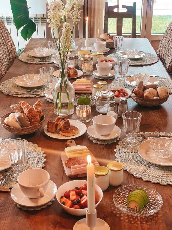 a long table with plates of food and candles at Quinta Amarela - B&B in Nazaré