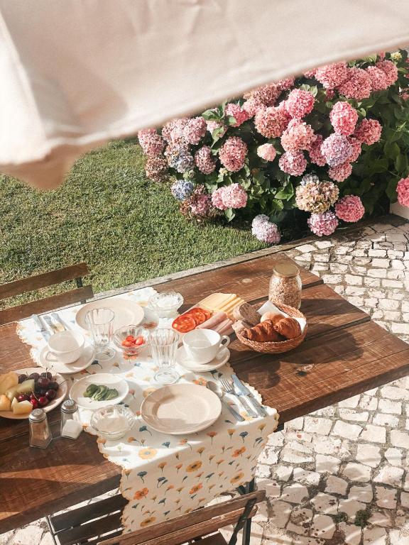 a picnic table with food and a bunch of flowers at Quinta Amarela - B&B in Nazaré