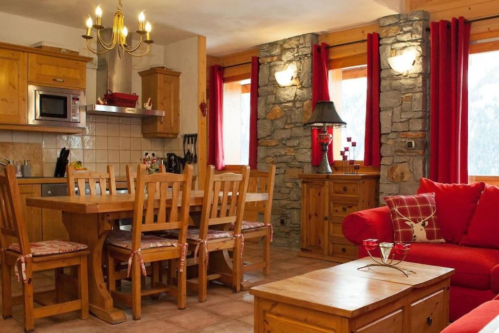 Il comprend une cuisine et un salon avec une table et un canapé rouge. dans l'établissement Venus - 2 bedroom apartment next to the slopes, à Sainte-Foy-Tarentaise