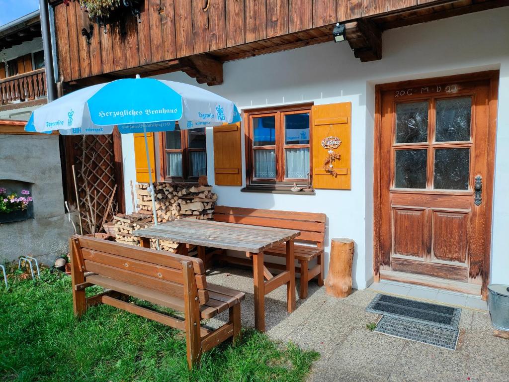 a picnic table with two benches and an umbrella at Schmidtler`s Nest in Warngau