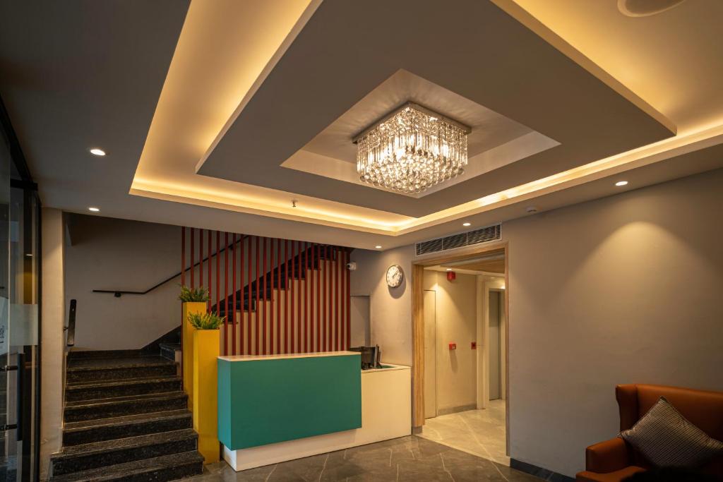 a lobby with a ceiling with a chandelier and stairs at Sparrow Hotels Alwar, Sariska in Alwar
