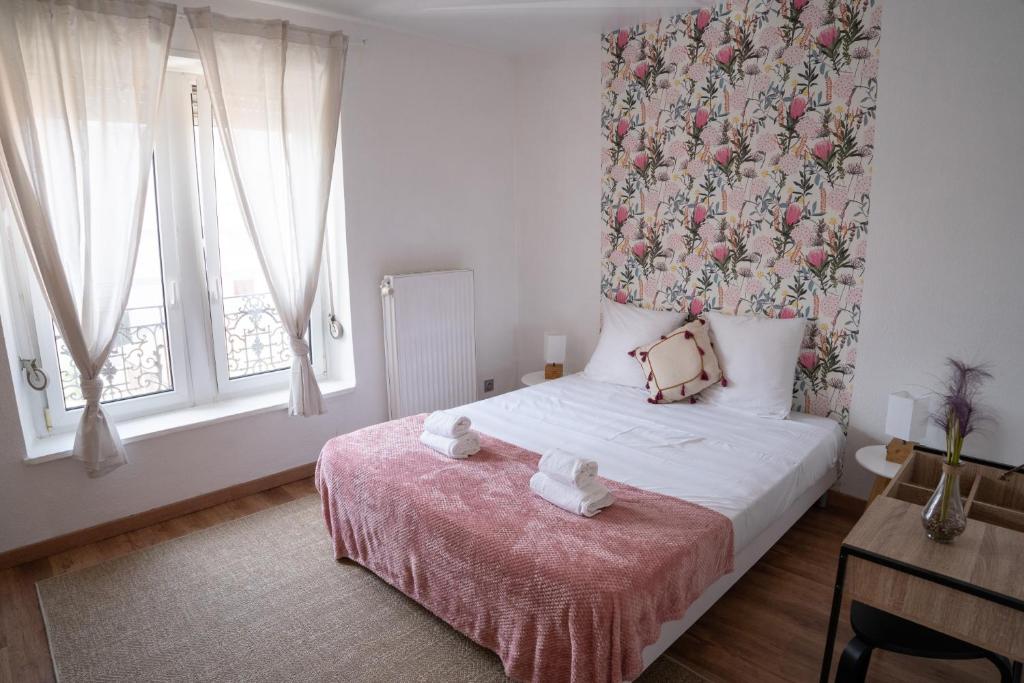 - une chambre avec un lit orné d'un mur fleuri dans l'établissement Le Luma, à Colmar