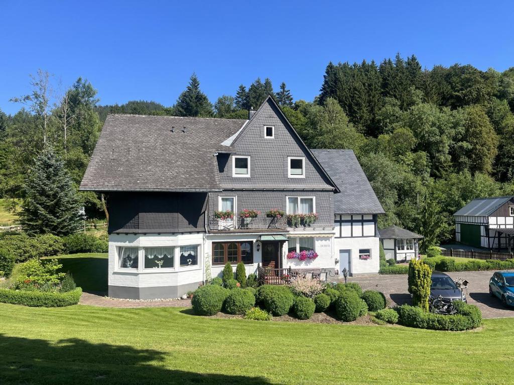 a large house with a black and white at Haus Schmitten in Winterberg