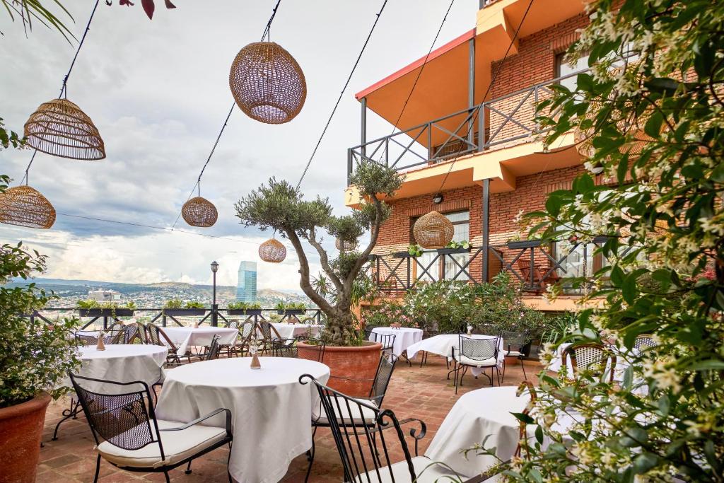 un patio de un restaurante con mesas y sillas en GINGER Hotel en Tiflis