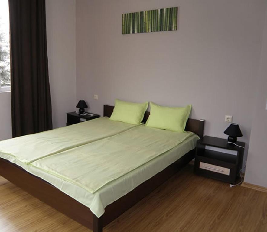 um quarto com uma cama grande e 2 almofadas verdes em Belogradchik View Apartment em Belogradchik