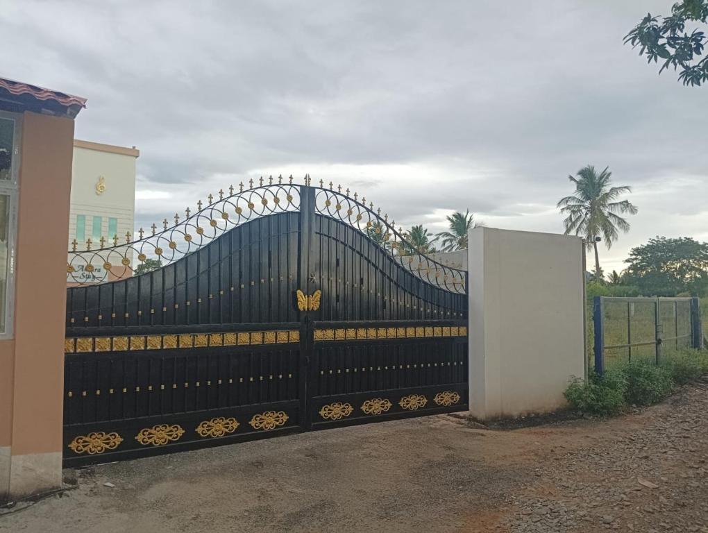 una cerca negra con una puerta decorada en oro en ANTARA STAY, en Coimbatore