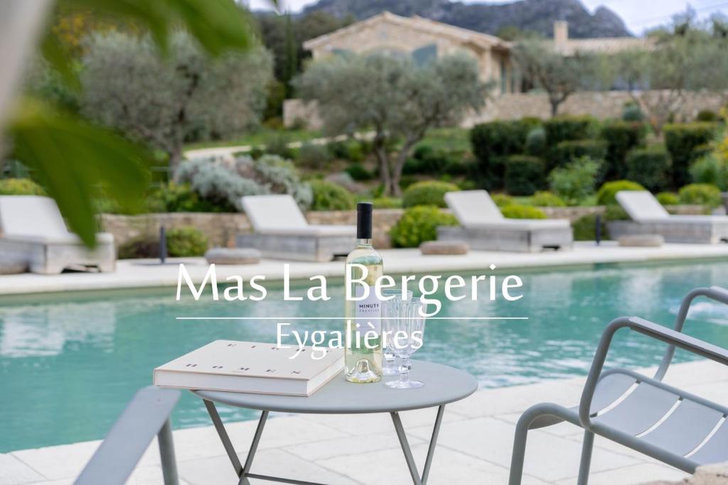 - une table et des chaises à côté de la piscine dans l'établissement Mas La Bergerie, à Eygalières