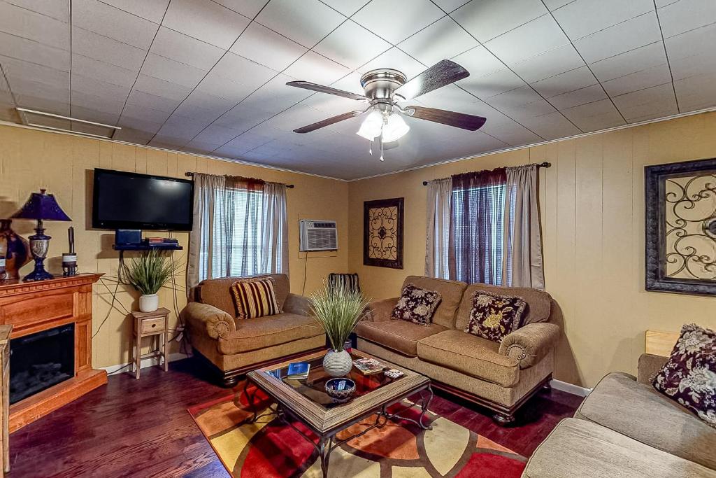 a living room with two couches and a ceiling fan at Keepin' it Reel in Avinger