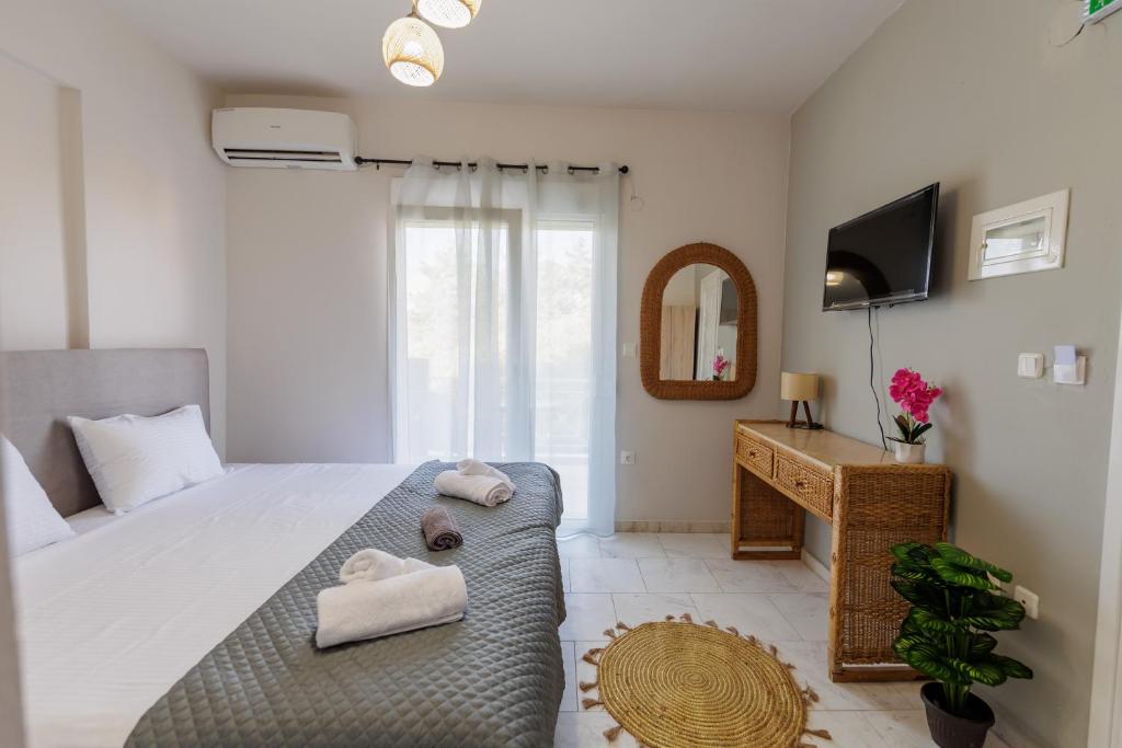 a bedroom with a large bed with towels on it at Marele Hills Boutique Apartments in Nea Fokea