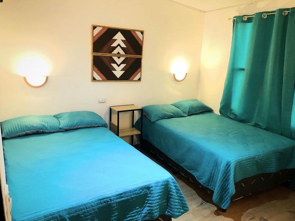ラ・ウニオンにあるINGRID LOFTSのブルーシーツ付きの客室内のベッド2台