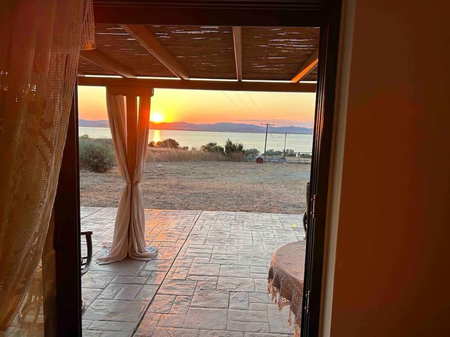 une porte ouverte avec vue sur le coucher du soleil dans l'établissement Moudros Sunset, à Moúdhros