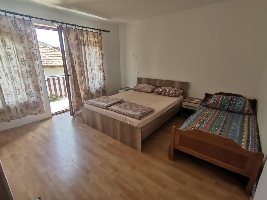 a bedroom with two beds and a sliding glass door at Guesthouse Zimovski in Peštani