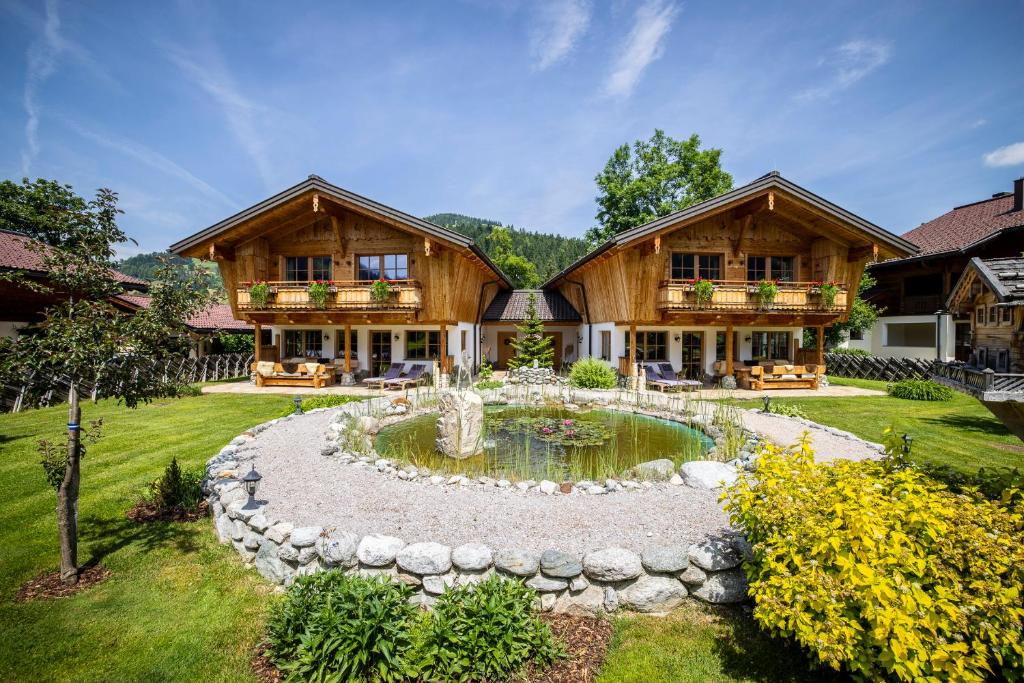 a home with a pond in front of a house at Chalets Wagrain in Wagrain