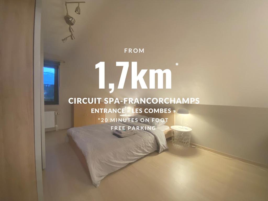 a bedroom with a bed and a sign that reads from kilogram at Hébergement à 20 min à pied du circuit Spa-Francorchamps in Malmedy