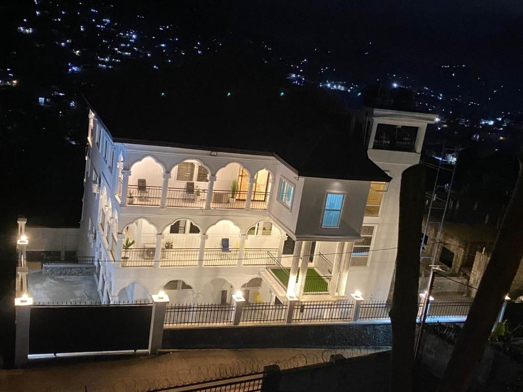 un gran edificio blanco con balcón por la noche en After 5 Apartment 3 2 spacious en-suite bedrooms, en Freetown
