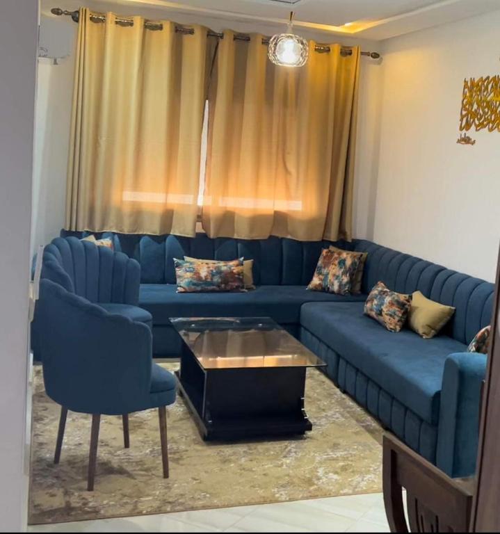 a blue couch and two chairs in a living room at Residence Rimal 5 Martil in Tétouan