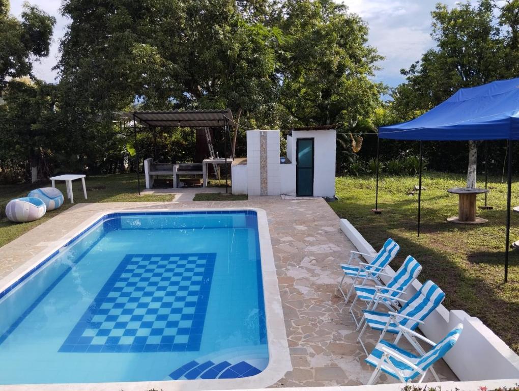 una piscina con sillas, una mesa y una tienda de campaña en Finca de Descanso - Sopetrán en Sopetran