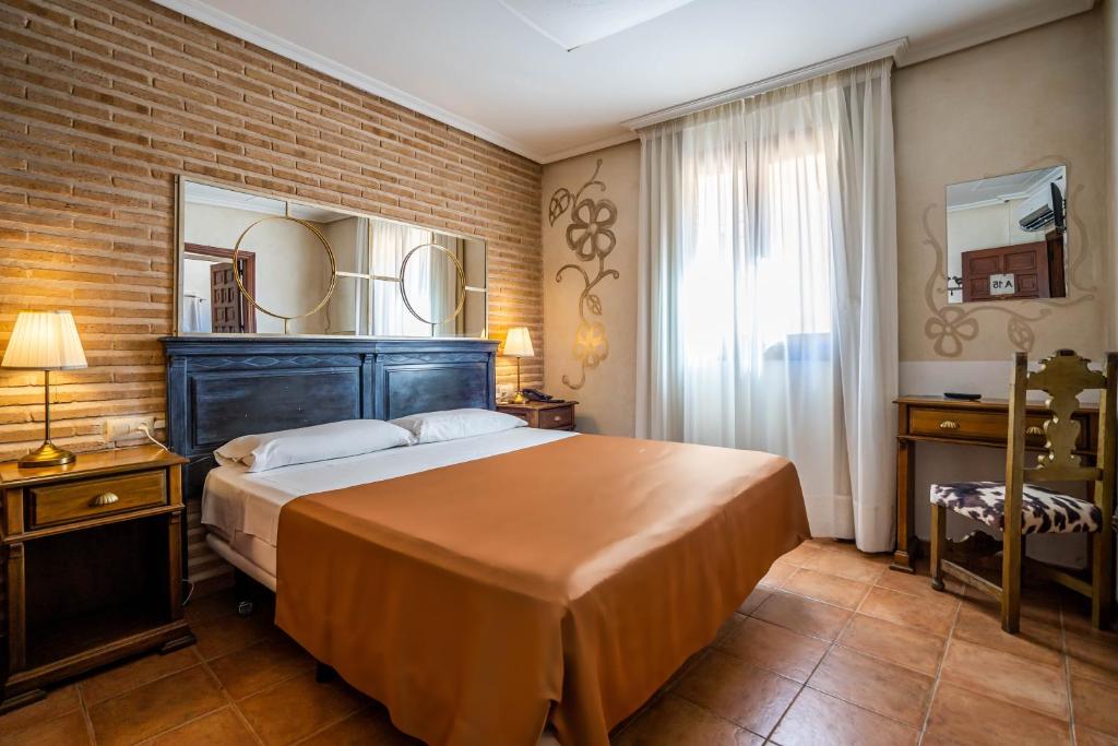 托萊多的住宿－YIT Puerta Bisagra，一间卧室设有一张大床和砖墙