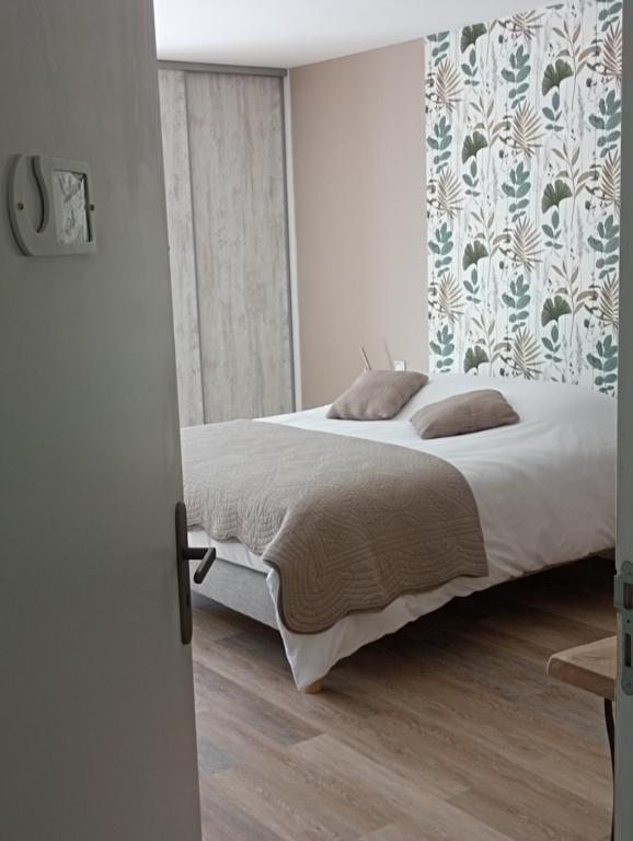 sypialnia z łóżkiem i ścianą w obiekcie Chambres et Tables d'hotes " O Doux Matins " aux portes de Chinon w mieście Rivière