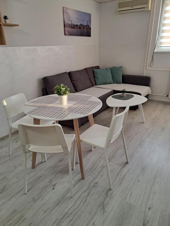 een woonkamer met een tafel en stoelen en een bank bij Ema lux 2 in Novi Sad