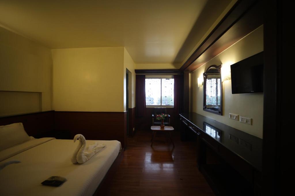 Uma cama ou camas num quarto em Jayaraj Residency
