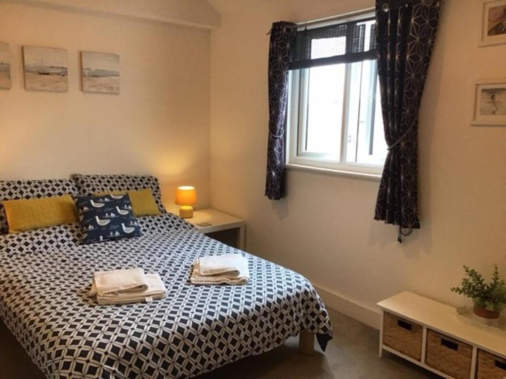 a bedroom with a bed and a window at Stunning penthouse apartment in Teignmouth in Teignmouth