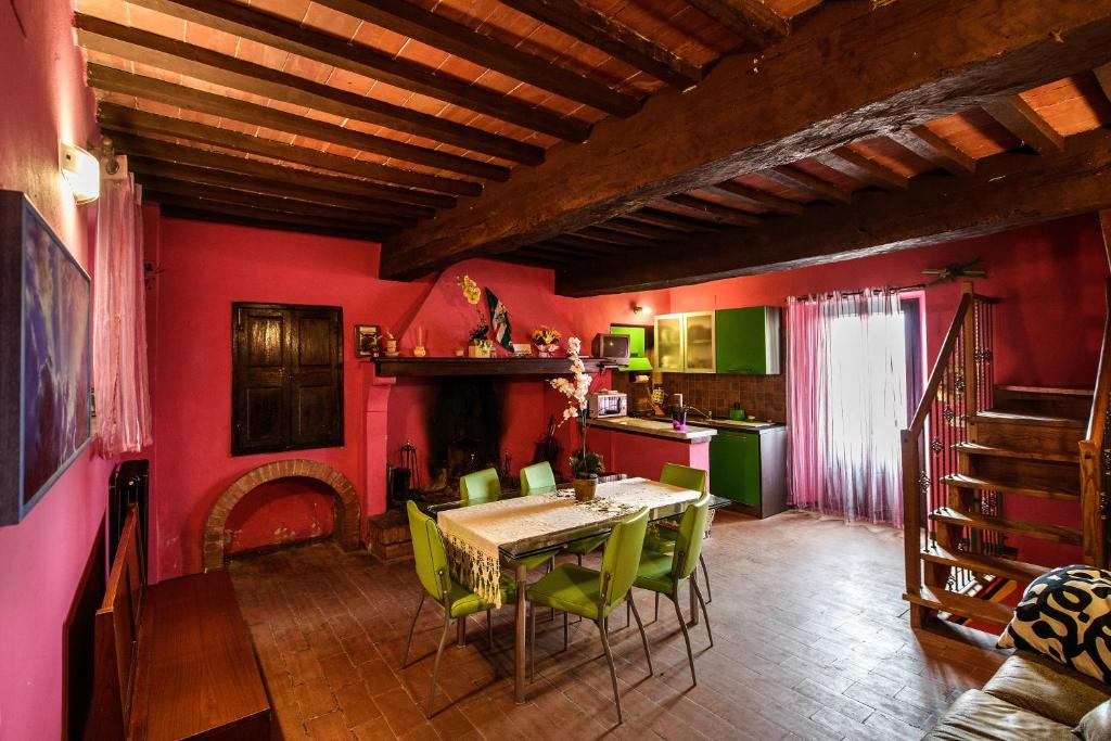 uma sala de jantar com uma mesa e cadeiras verdes em La Casa Dei Colori em Radicondoli