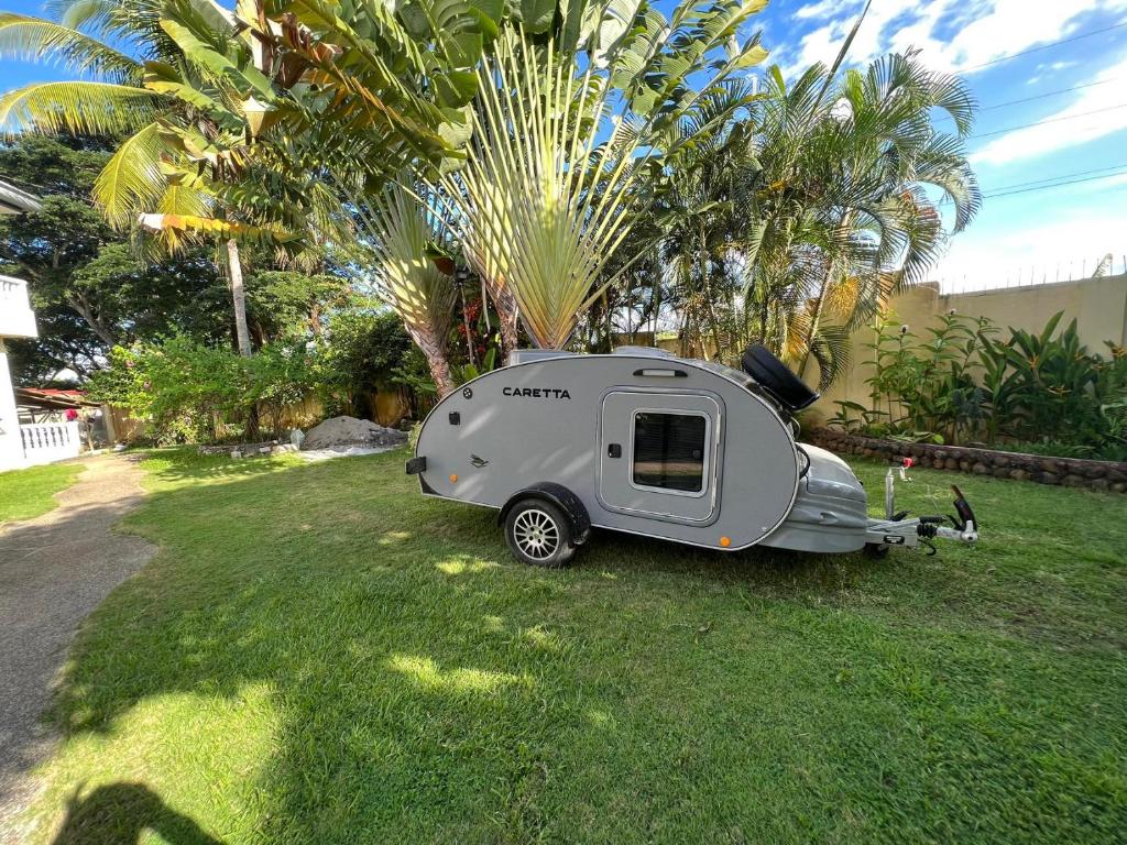 uma pequena caravana estacionada na relva num quintal em Camping car room 