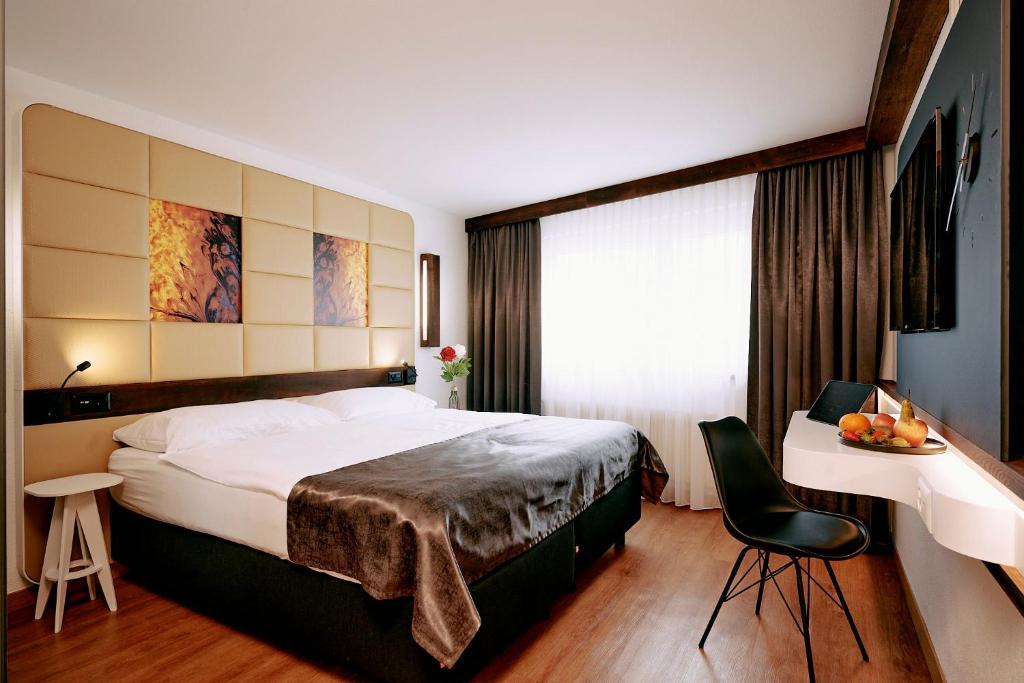 a hotel room with a large bed and a table at Elite in Visp