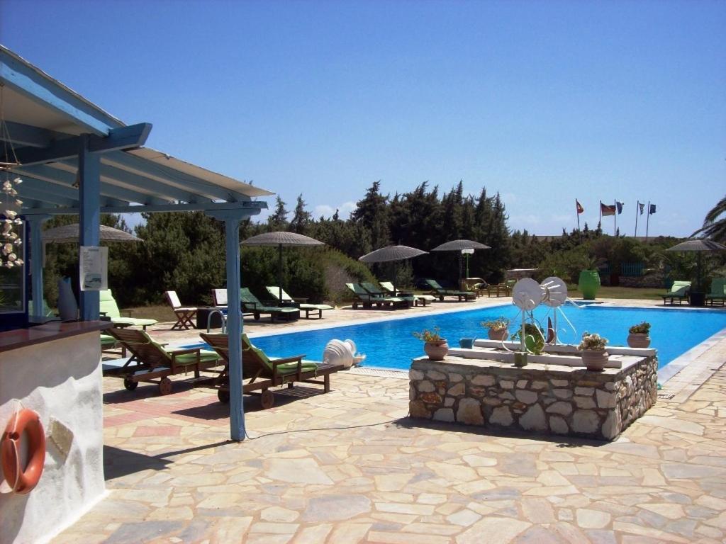 a swimming pool with chairs and a patio with a pool at Kalimera Paros in Santa Maria