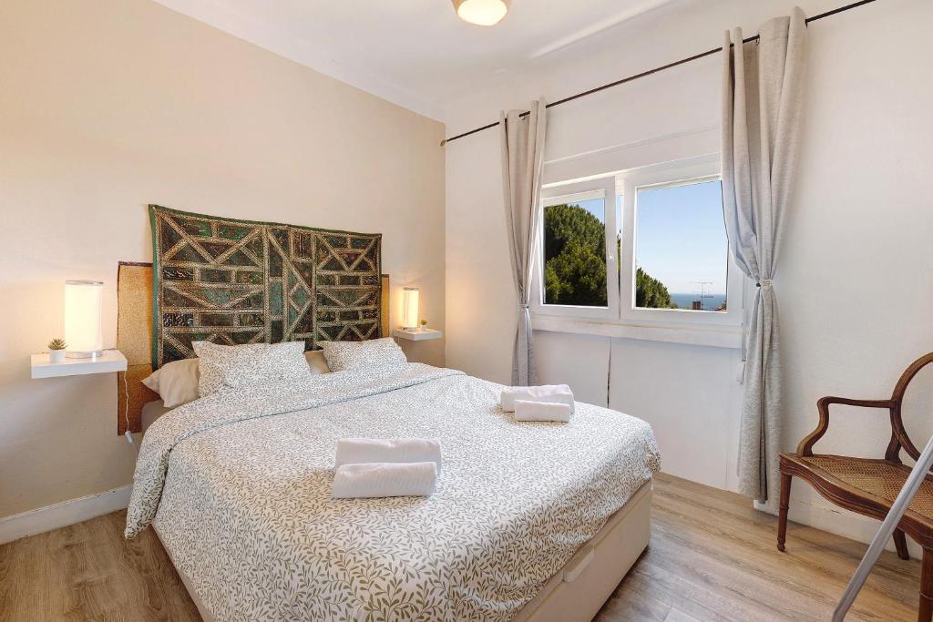 a bedroom with a large bed and a window at Bisa's house in Estoril