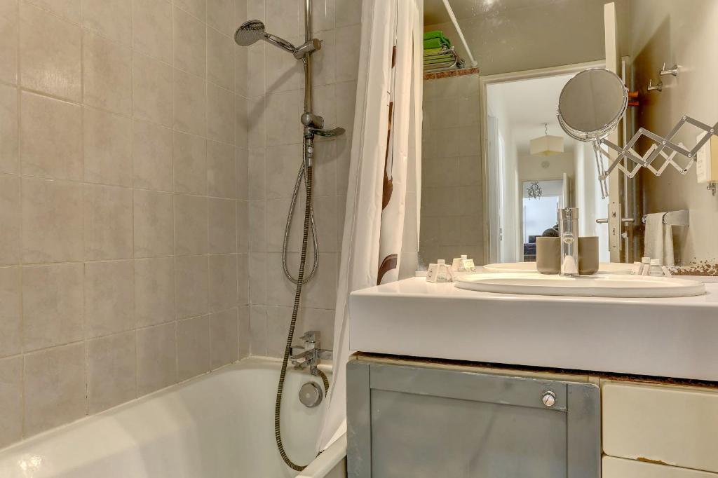 a bathroom with a shower and a sink and a tub at Le Charlemagne- Boulogne in Boulogne-Billancourt