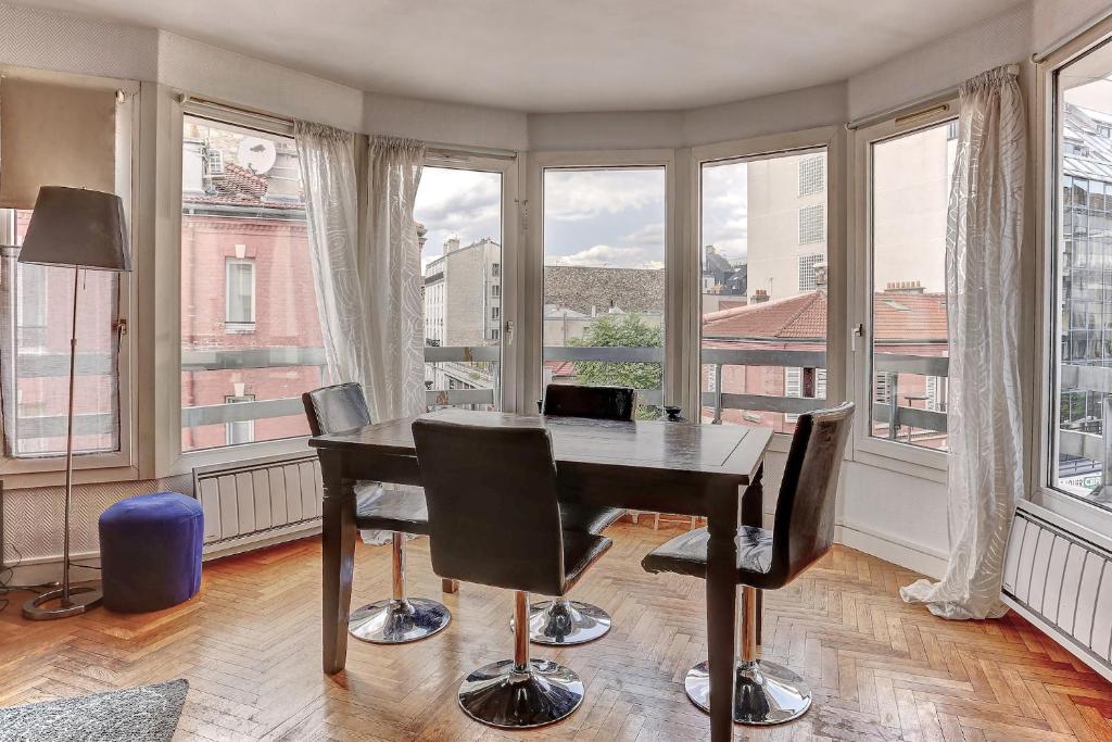 a room with a desk and chairs and windows at Le Charlemagne- Boulogne in Boulogne-Billancourt