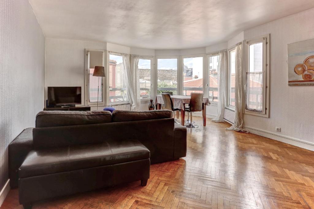 a living room with a couch and a table at Le Charlemagne- Boulogne in Boulogne-Billancourt