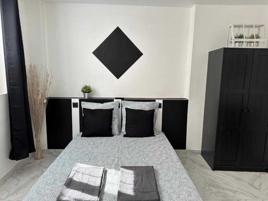 a bedroom with a bed with black and white at La maison de Giulia Menton in Menton