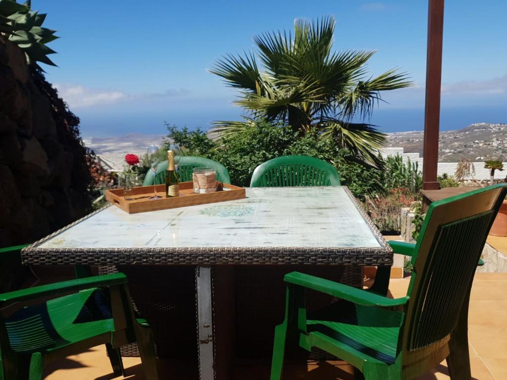 a table with green chairs on a patio at Lo mejor de la montaña, Vista Bonita in San Miguel de Abona