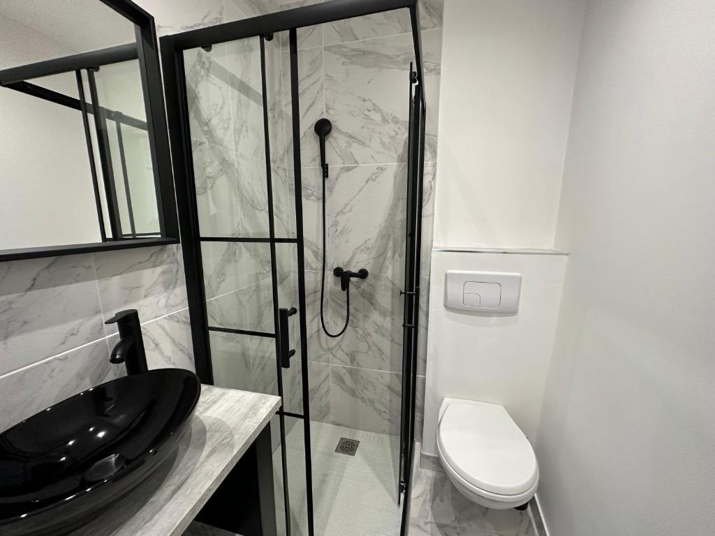 a bathroom with a glass shower and a toilet at La maison de Giulia Menton in Menton