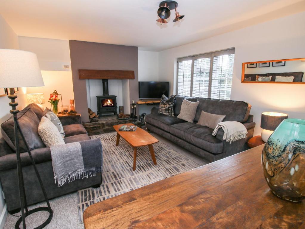 a living room with couches and a fireplace at Clematis Cottage in Shrewsbury
