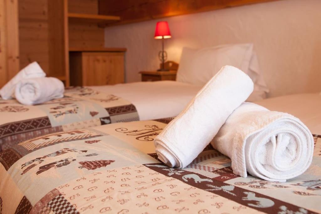 two beds with towels on them in a hotel room at L&#39;Aiglon - spacious 2-bedroom apartment with log fire in Sainte-Foy-Tarentaise