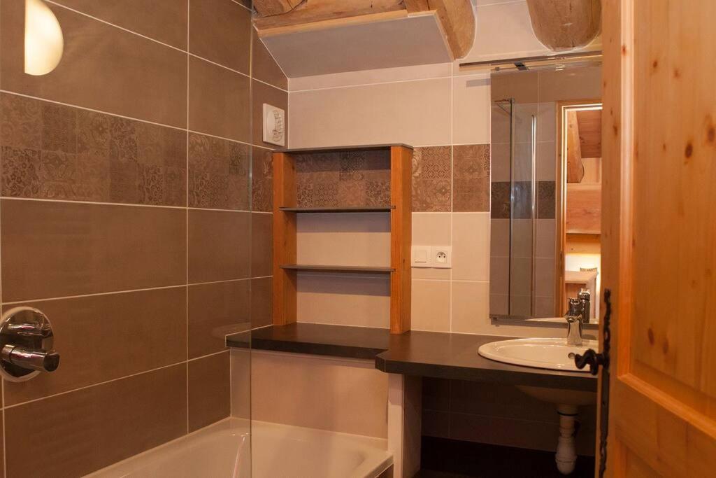 a bathroom with a sink and a tub and a mirror at L&#39;Aiglon - spacious 2-bedroom apartment with log fire in Sainte-Foy-Tarentaise