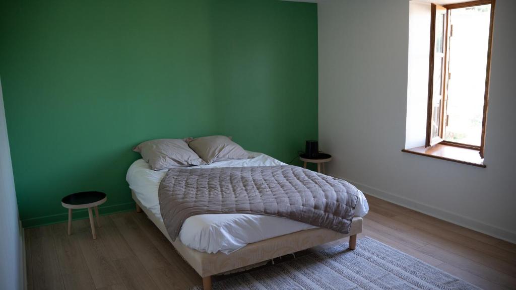a green bedroom with a bed in a room at Appart O moines in Jalogny